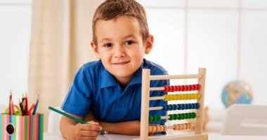 Little schoolboy sitting at a desk and studying